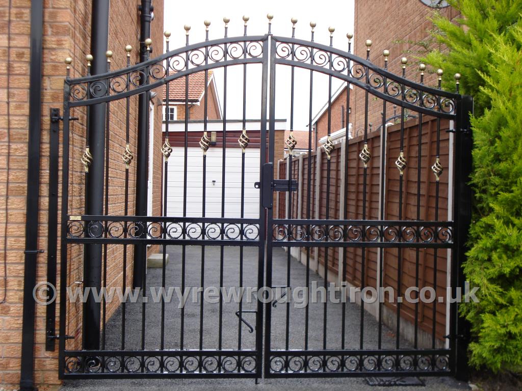 Tall double arched gates with railheads, scrolled tail circles, black powder coating and gold finish created for Lytham St Annes customer.